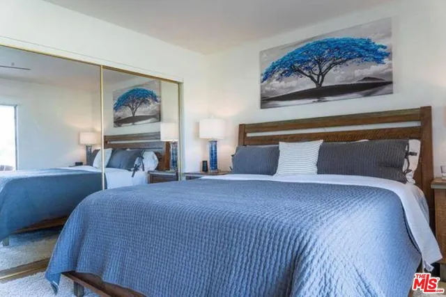 a bedroom with a bed and wall painting