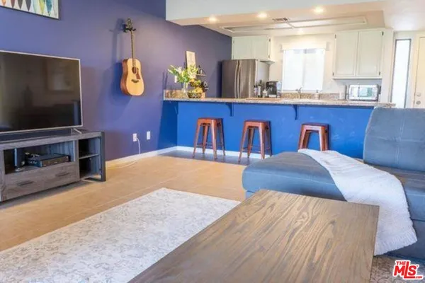 a bedroom with a bed and painting on the wall