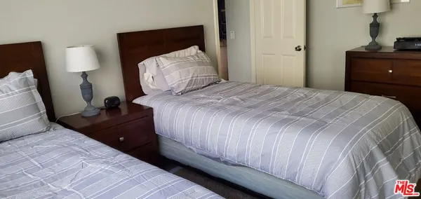 a bedroom with a bed and a lamp on dresser