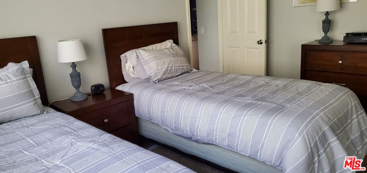 77116 Pauma Valley Way Palm Desert, CA 92211 - Photo 7 of 15 a bedroom with a bed and a lamp on dresser