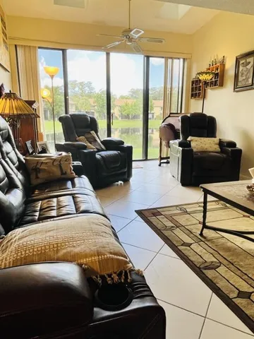 a living room with furniture and a floor to ceiling window