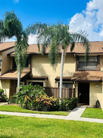 a front view of a house with a yard and potted plants