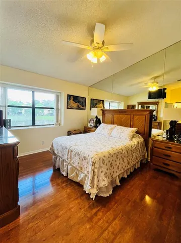 a bedroom with a bed mirror and window
