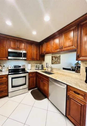 a kitchen with stainless steel appliances granite countertop a stove sink microwave and cabinets
