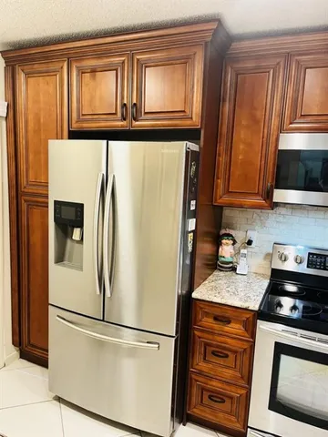 a white refrigerator freezer and a stove sitting inside of a kitchen
