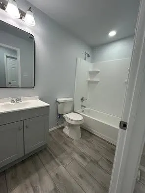 a spacious bathroom with a double vanity sink toilet and a mirror