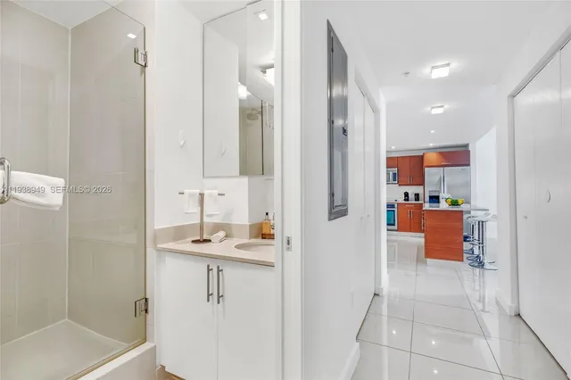 a bathroom with a sink mirror and shower