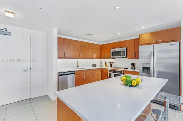 a kitchen with stainless steel appliances a refrigerator sink stove microwave and cabinets