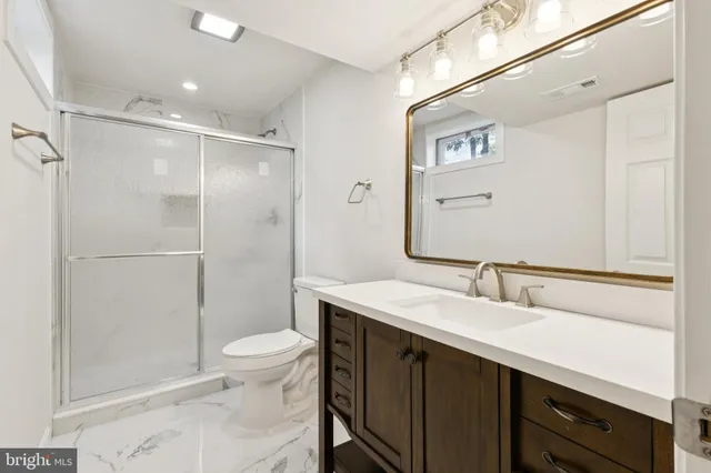 a bathroom with a double vanity sink toilet mirror and shower