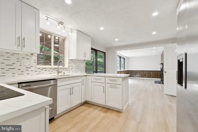 a kitchen with stainless steel appliances granite countertop a sink stove and cabinets