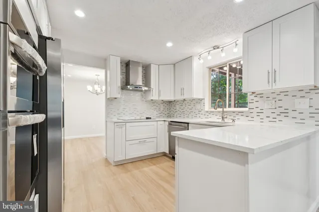a kitchen with a sink cabinets stainless steel appliances and a window