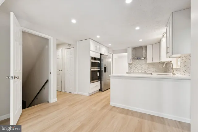 a kitchen with stainless steel appliances granite countertop a refrigerator and a sink