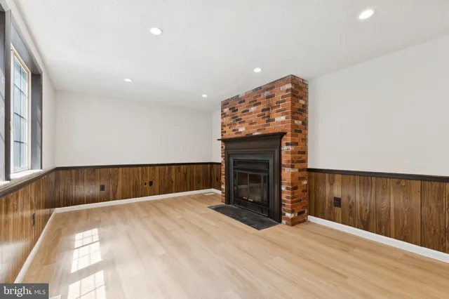 an empty room with wooden floor and fireplace