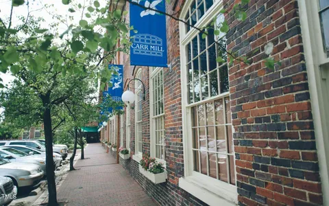 a view of a street with brick wall and potted plants