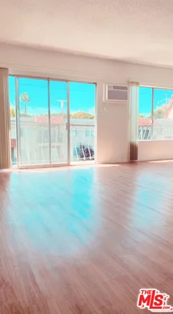 a big room with wooden floor and windows