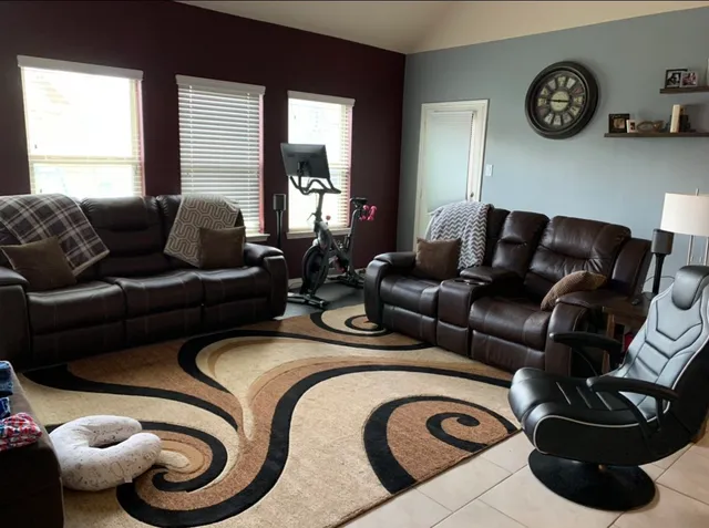 a living room with furniture a clock and a window