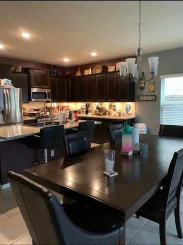 a kitchen with a table chairs stove and kitchen view