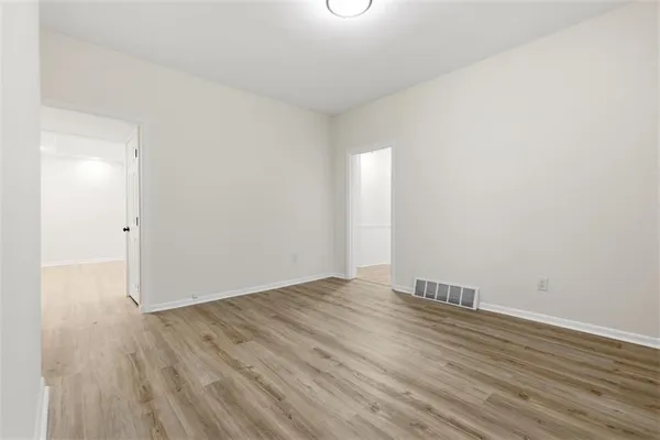 a view of an empty room with wooden floor