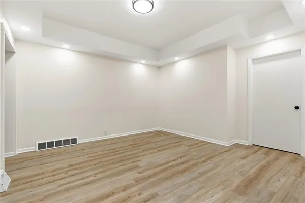 a view of an empty room with wooden floor