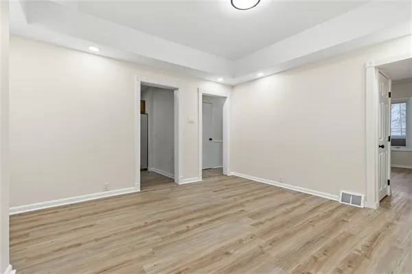 a view of an empty room with wooden floor