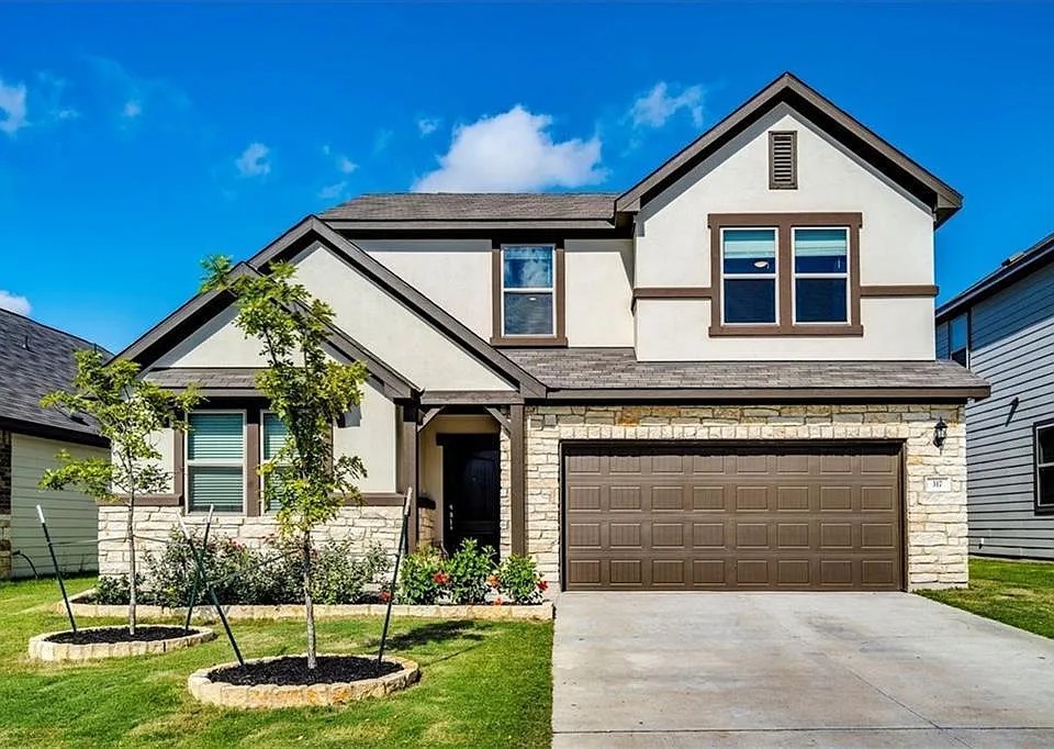 317 Capstone Road Liberty Hill, TX 78642 - Photo 1 of 10 View of front of house with stone siding, stucco siding, a garage, concrete driveway, and a front lawn