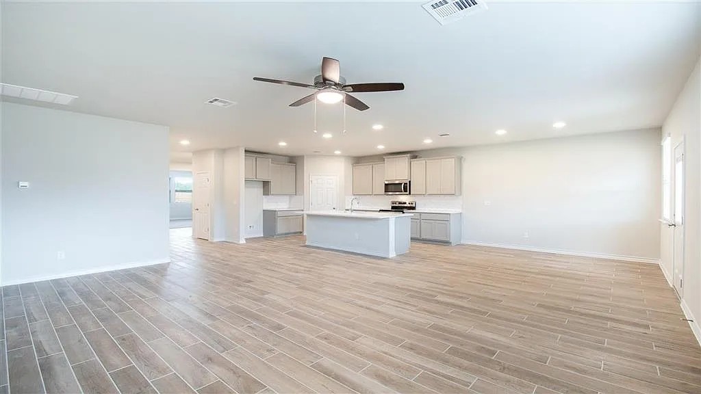 317 Capstone Road Liberty Hill, TX 78642 - Photo 10 of 10 Kitchen with open floor plan, light countertops, ceiling fan, gray cabinets, and wood tiled floors