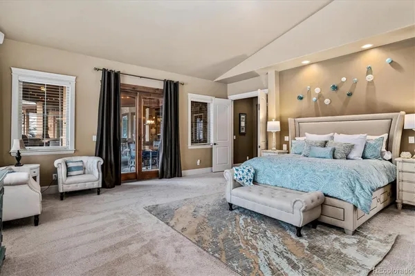 a spacious bedroom with a bed and glass walk in closet