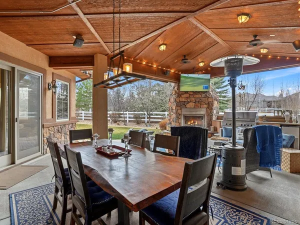 a dining room with furniture a chandelier and wooden floor