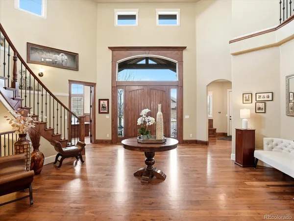 a view of a livingroom with furniture wooden floor windows and a fireplace