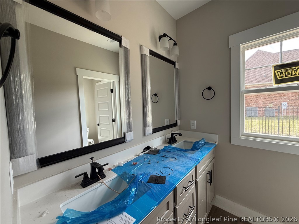 132 Ridge Stone Drive Autryville, NC 28318 - Photo 22 of 26 a bathroom with a granite countertop sink and a mirror