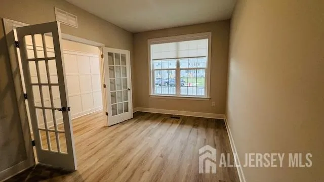 an empty room with wooden floor and windows
