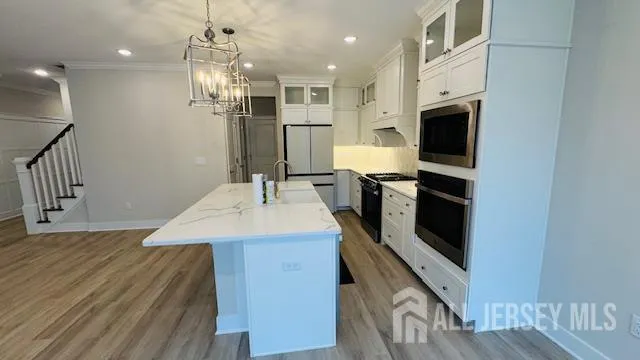 a kitchen with kitchen island a sink appliances and cabinets