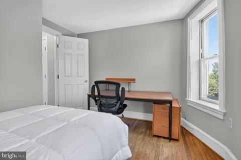 a bedroom with a bed and wooden floor