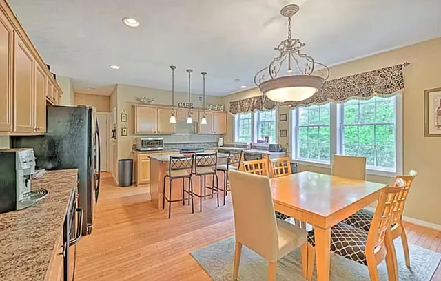 a view of a dining room and livingroom with furniture wooden floor a chandelier