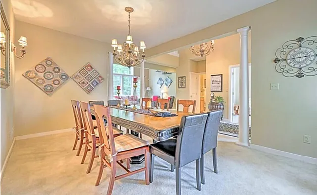 a dining room with furniture a chandelier and a rug