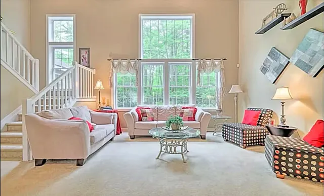 a living room with furniture and a floor to ceiling window