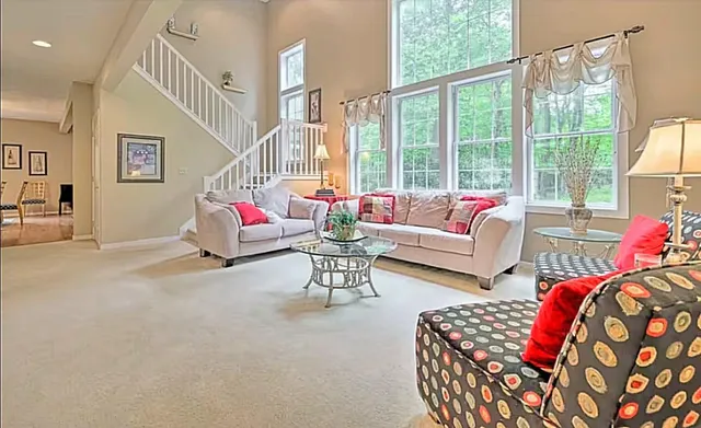 a living room with furniture and floor to ceiling windows