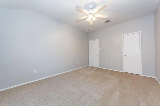 an empty room with windows and fan