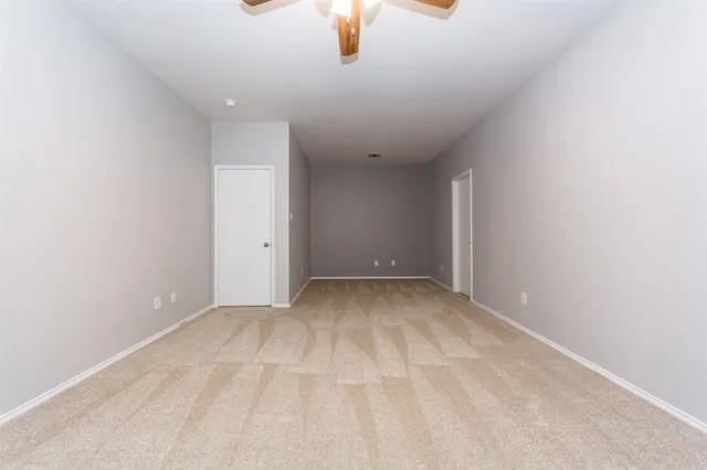 an empty room with chandelier fan