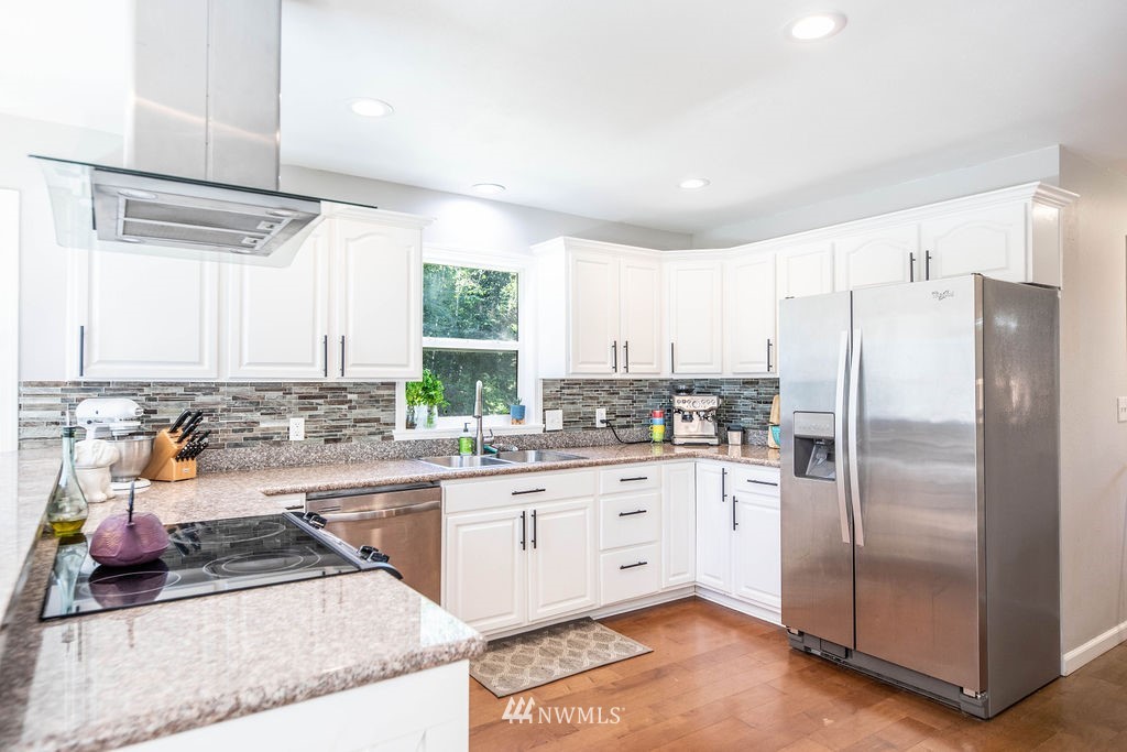 10627 Cherry Road Lake Stevens, WA 98258 - Photo 10 of 38 a kitchen with stainless steel appliances granite countertop a refrigerator a sink a stove and white cabinets with wooden floor