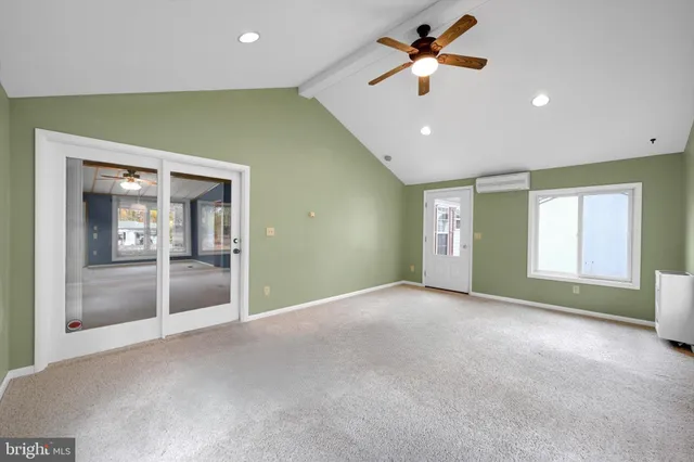 a view of n empty room with window and ceiling fan