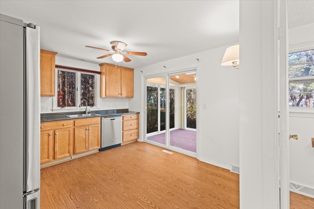 139 Burt Street, Unit 6 Norton, MA 02766 - Photo 13 of 31 a open kitchen with stainless steel appliances granite countertop a refrigerator a sink dishwasher and a fireplace with wooden floor