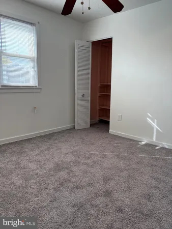 an empty room with closet and windows