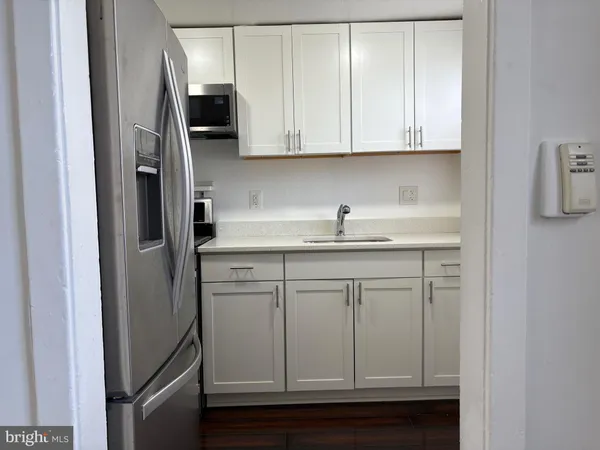 a kitchen with stainless steel appliances granite countertop white cabinets and refrigerator