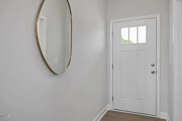 an entryway view with wooden floor and a window