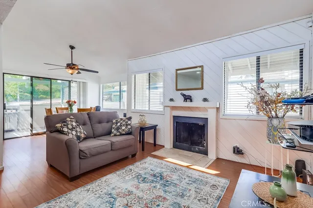 a living room with furniture a large window and a fireplace