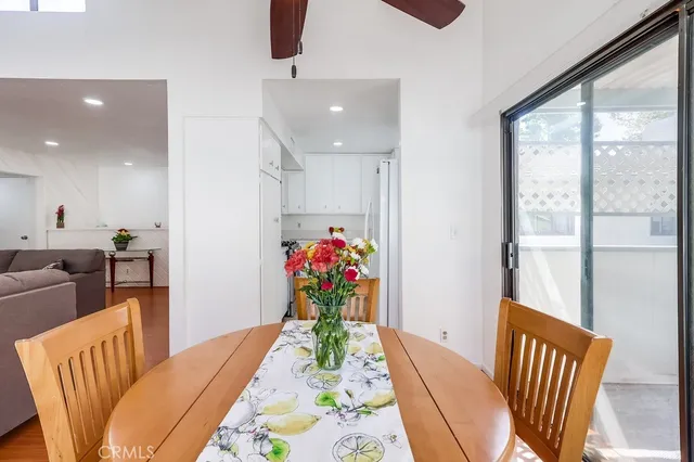 a view of a dining room with furniture a potted plant and wooden floor