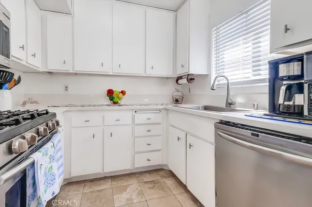 a kitchen with white cabinets and appliances