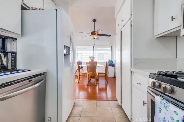 a hallway with a stove a refrigerator and livingroom view