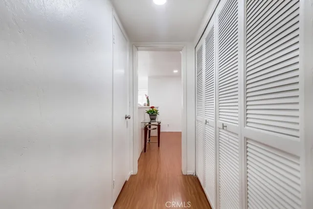 a view of a hallway with wooden floor and furniture